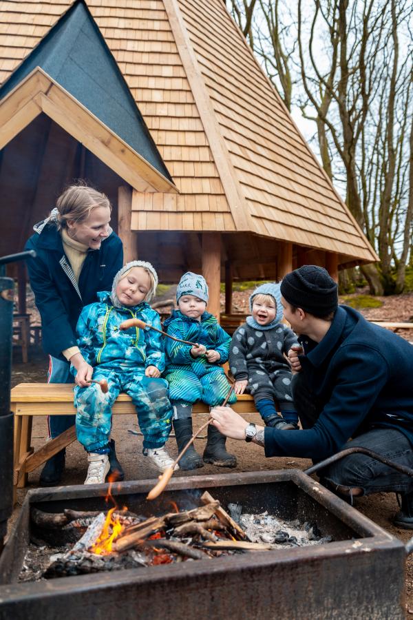 Familie rister pølser ved Max Henius hytten i Rebild Bakker